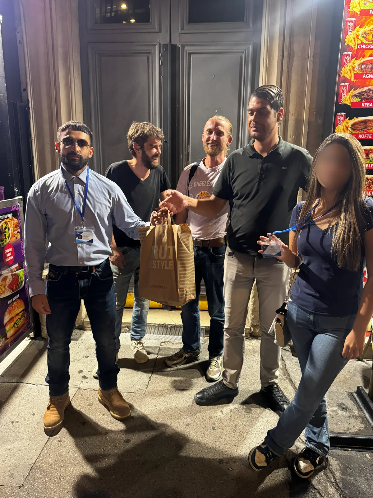 Bénévoles d’Ascension Solidaire remettant un sac repas à des personnes sans abri