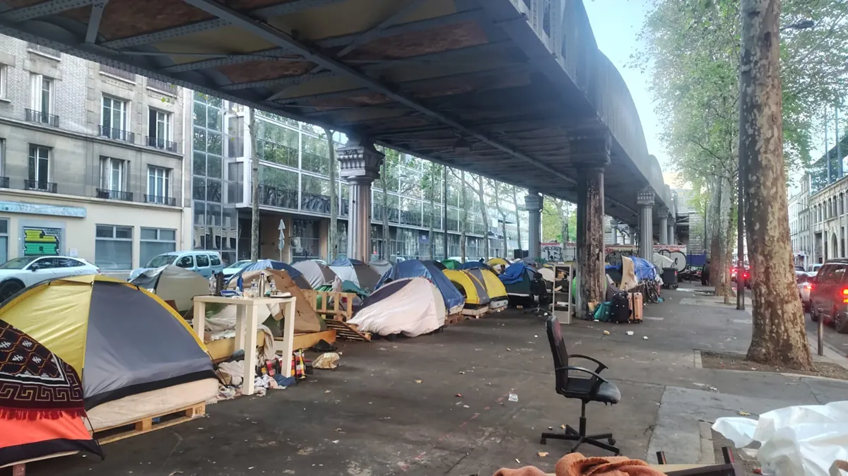 Alignement de tentes de personnes sans abri sous le métro aérien à Paris